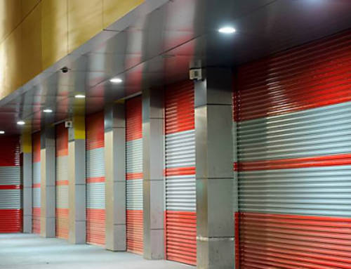 Exterior Of A Commercial Warehoue With Orange Roller Doors